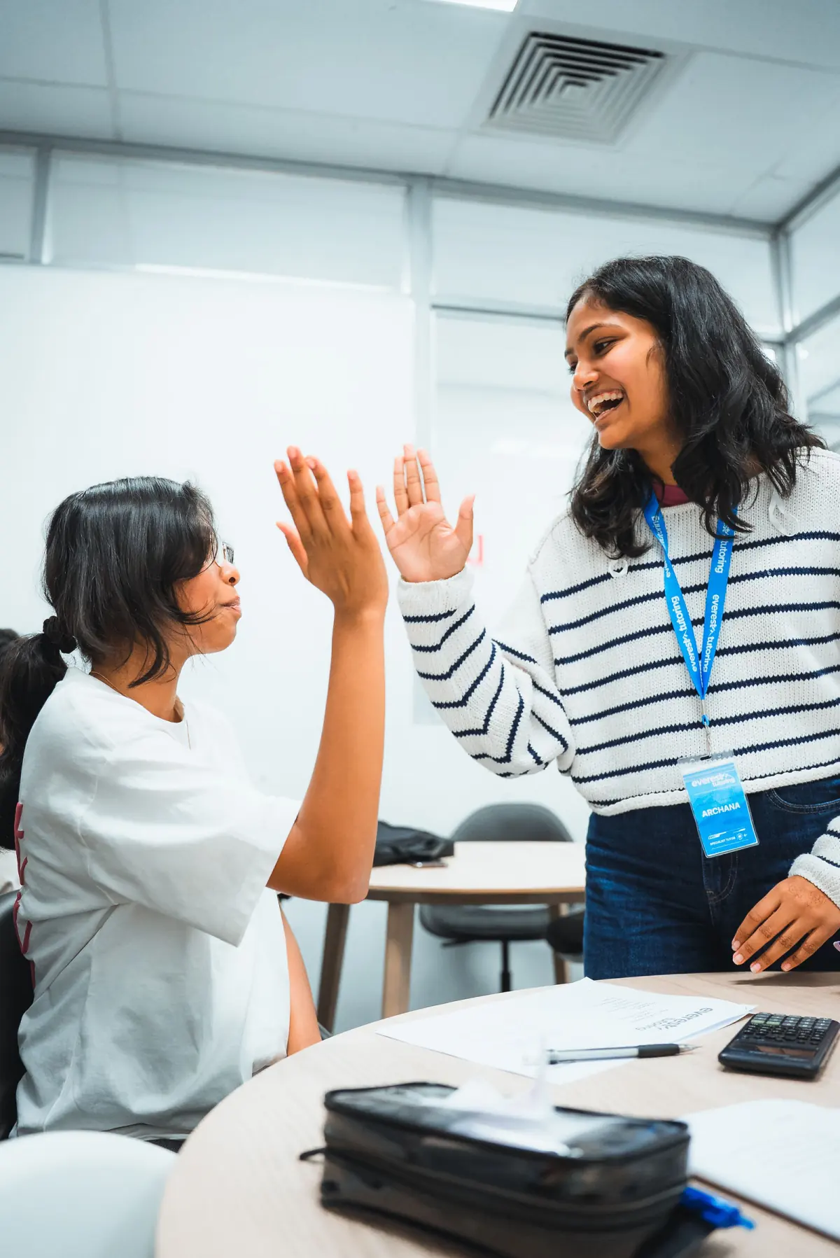 An Everest tutor high-fiving a student after a class