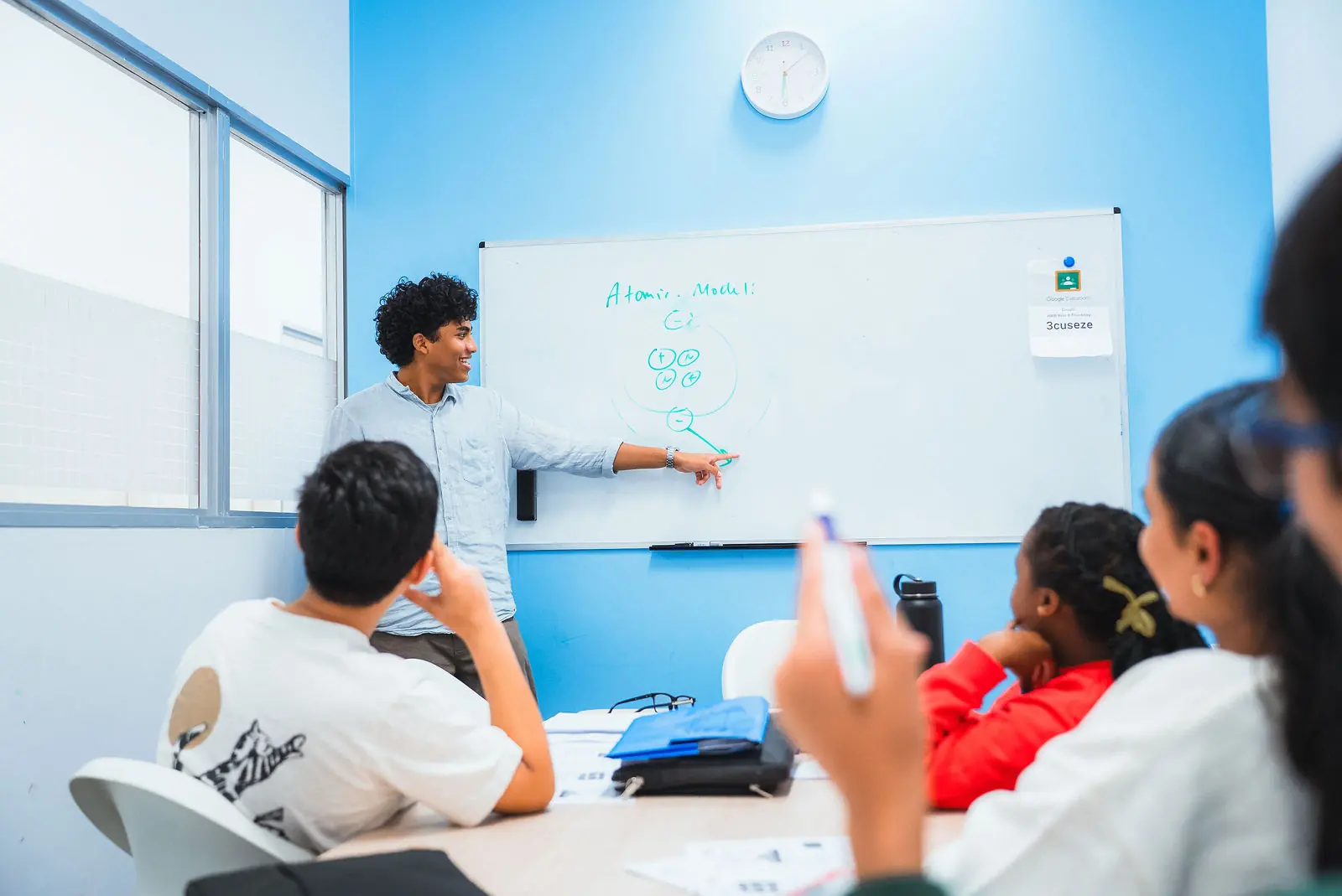 A small Everest class in session, tutor at the board and students at the tables